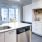 Spacious and well lit kitchen with wood floors and stainless steel appliances. 