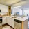 brightly lit kitchen with counter open to living room